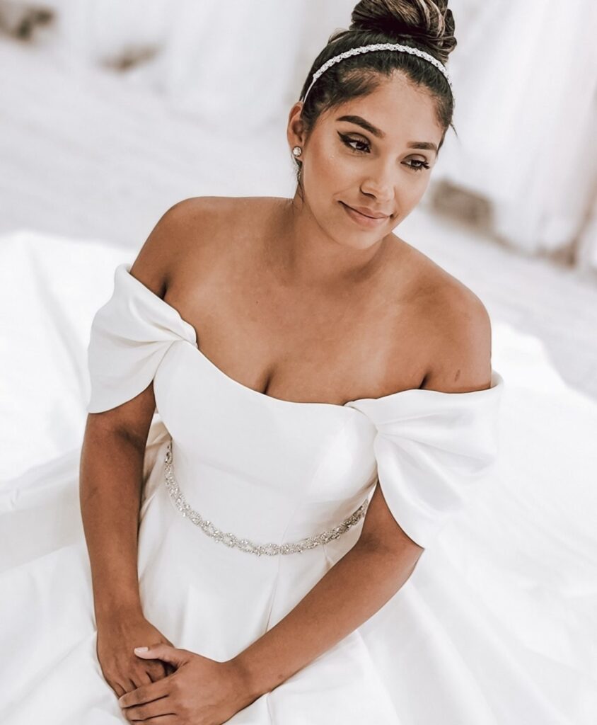 bride sitting in classic satin wedding dress with sleeves